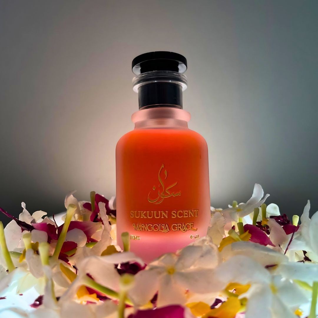 Sukuun Scent Magnolia Grace Eau de Parfum 50ML bottle surrounded by white and pink flowers.