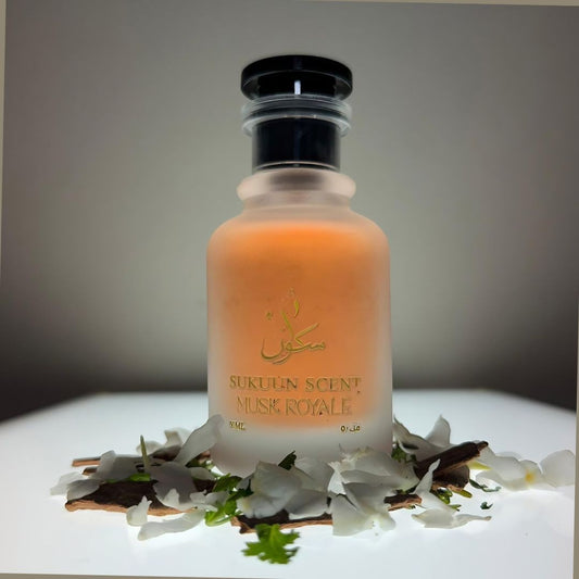 Sukuun Scent Musk Royale 50ML Eau de Parfum bottle with gold lettering, surrounded by white petals and cinnamon sticks.