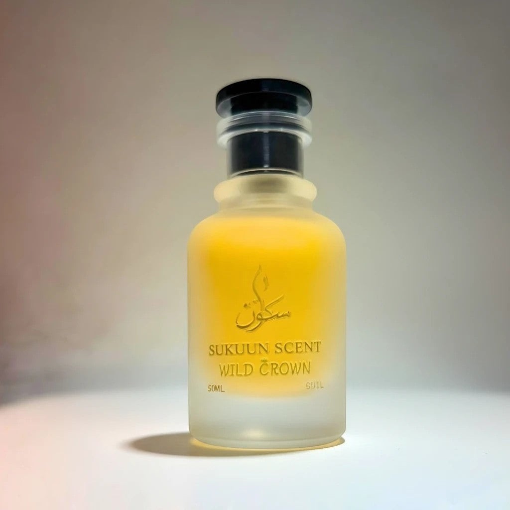 Sukuun Scent Wild Crown Eau De Parfum, a frosted glass bottle with yellow liquid and a black cap.